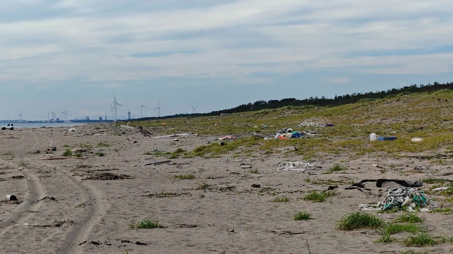 Fishing nets and plastic litter scattered across a sandy beach