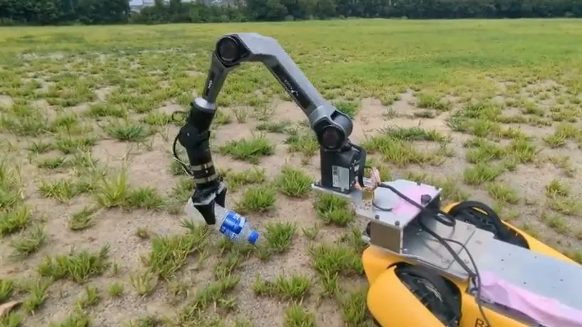 A collection robot gripping a plastic bottle with its arm