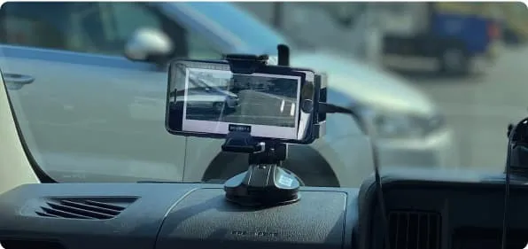 A smartphone mounted in a car films the road